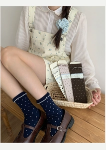 Close-up of navy blue polka dot socks with ruffled cuffs in soft cotton blend fabric