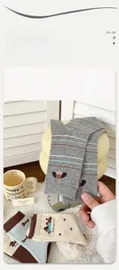 Detail der süßen Dackel-Stickerei auf gestreiften und gepunkteten Baumwollsocken