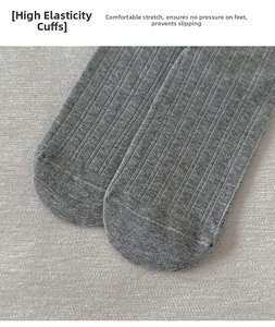 Détail de chaussettes grises côtelées montrant l'élasticité et la maille souple