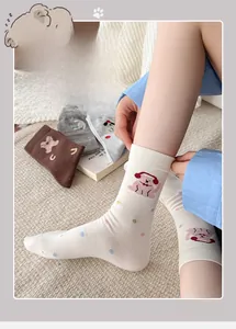 Dettaglio di calze in cotone bianco con motivi di animali rosa e pois colorati per donna