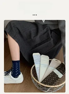 Detail of knit crew socks with 3D polka dots and sweet ruffled cuffs in multiple colors