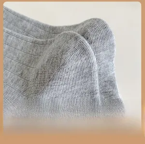 Dettaglio del tallone rinforzato e della trama a maglia a coste delle calze di cotone grigio