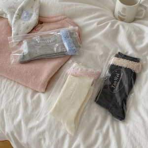 Three-pair set of cotton crew socks with plush lace trim in cozy home setting