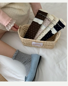 Close-up of ballet-style polka dot crew socks with frill cuffs in a woven basket