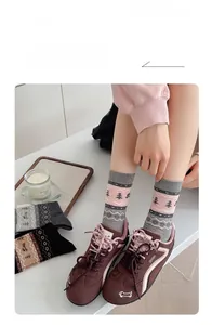 Detail showing jacquard knit patterns of trees and puppies on cotton crew socks