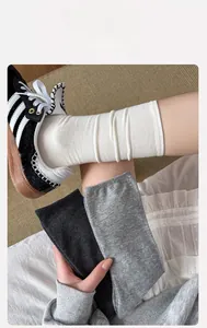 Detailansicht der Rippstruktur und elastischen Bündchen grauer und weißer Socken