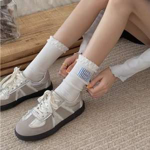 White ribbed lace socks with brand label and grey suede patchwork sneakers