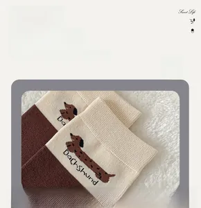 Detail des Dackel-Strickmusters und des gerippten Bündchens an Baumwollsocken für Damen