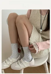 Detail of grey polka dot socks with ruffled edges and knitted texture for women