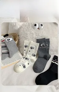 Detail of sheep cartoon pattern on gray knitted cotton socks for autumn wear