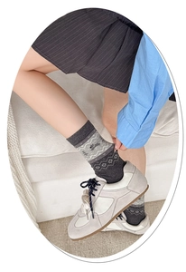 Detail of grey Fair Isle crew socks featuring jacquard snowflake and puppy patterns