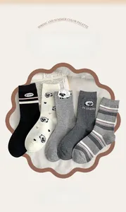 Detailed flat lay of five cute flocking sheep cartoon mid-calf socks in various grey tones