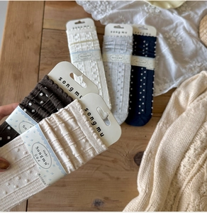 Close-up of 3D polka dot knit socks with original brand packaging on wooden table