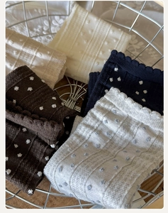 Detailed view of assorted color cotton socks with 3D polka dots and ruffle lace trim