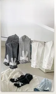 Detailed view of pearl bow socks with lace bunny ears and sweet ruffled edge trim