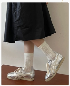 Détail de baskets rétro argentées avec chaussettes en tricot et nœud au style urbain