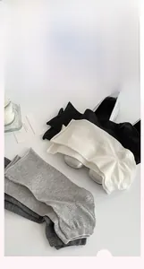 Dettaglio di scaldamuscoli a coste multicolore con scarpe argento in stile minimalista