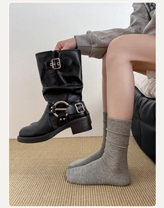 Detailansicht schwarzer Bikerboots aus mattem Leder mit Metallring und Schnallen
