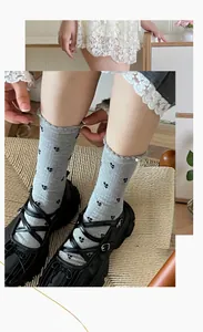 Close-up of gray cotton socks with black floral patterns and Mary Jane platform shoes