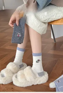 Close-up of cute koala embroidery and textured wool fabric on stylish thermal winter socks
