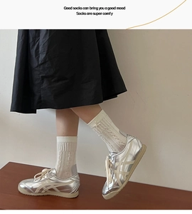 Gros plan de chaussettes mi-mollet blanches à maille torsadée et bords côtelés