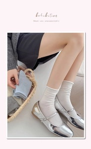 Detailed texture of rib-knit cotton socks with lettuce edge trim and 3D bow accent