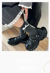 Detail of dark grey crew socks with white bows and dots paired with Mary Jane shoes