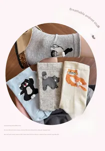 Detail showing various colors of cartoon cat tube socks with white 3D pom-pom tail design