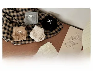 Détail de chaussettes en tricot torsadé avec nœuds en plusieurs tons neutres