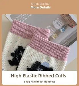 Detailed view of cream knit sock featuring pink ribbed cuff and black bear pattern