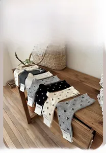 Detailed color display of mid-tube socks with bowknots and polka dots on wood bench