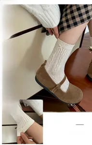 Détail de chaussettes blanches en maille torsadée avec nœud perlé et bords ondulés