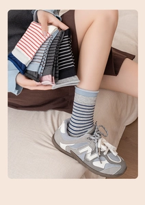 Detailed close-up of colorful striped cotton mid-calf socks with ribbed cuffs on model