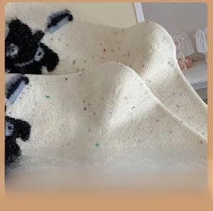 Detail of knit socks with colorful speckles, cartoon dog patterns and reinforced heel