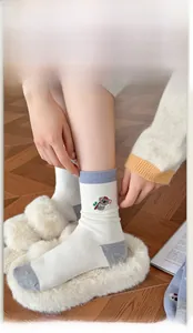 Detail of high-elasticity ribbed cuff and cute koala embroidery on white wool socks