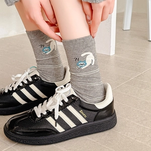Calze grigie carine con gatti e sneakers nere per un look casual in stile accademico