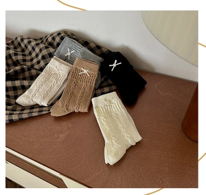 Détail de chaussettes en maille torsadée avec de petits nœuds en couleurs assorties