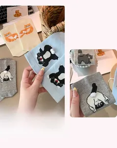 Detailed knit of cute cartoon cat socks featuring 3D plush tail pom-poms for women