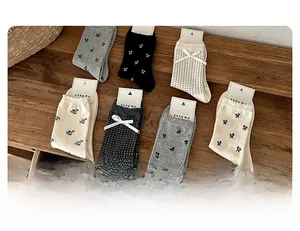 Detail of assorted grey and beige cotton socks with bow decorations and floral patterns