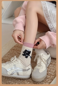 Detail of cartoon bear mid-calf socks with colorful polka dots and pink ribbed cuff