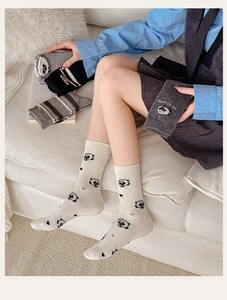 Detailed close-up of cute cartoon sheep patterns and textures on grey cotton socks