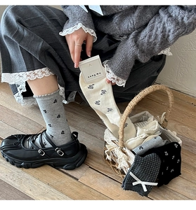 Detail view of cotton crew socks with cherry patterns, polka dots and white bows