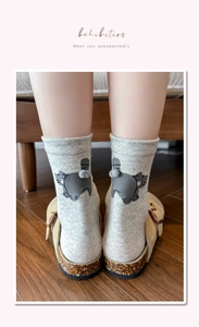 Detail of light gray crew socks with cute cartoon cat back and 3D plush ball tail