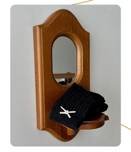 Détail de jambière noire en maille torsadée avec nœud blanc et perles