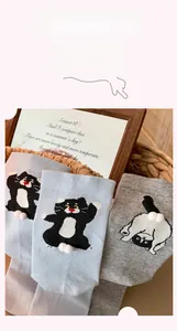 Detailed close-up of cute cat pattern socks with 3D pompoms in a cozy basket