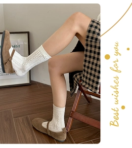 Détail du tricot torsadé de chaussettes mi-mollet blanches au style preppy