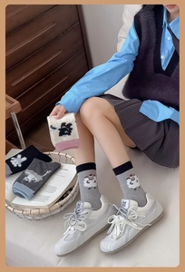Detail of knit cotton crew socks featuring cute cartoon sheep embroidery in various colors