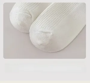 Detail of white knit socks featuring smooth seamless toe and ribbed texture pattern
