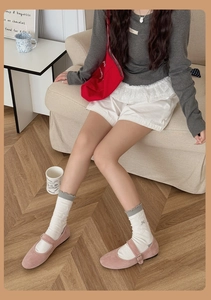 Détail de chaussettes blanches à volants brodées d'un ours et chaussures Mary Jane