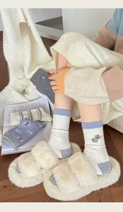 Detail of warm wool socks with cute koala embroidery and lavender patchwork patterns